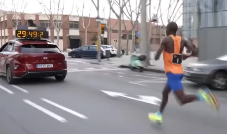 Ο Τζέικομπ Κιπλίμο που τρέχει πίσω από το αυτοκίνητο στον ημιμαραθώνιο της Βαρκελώνης το 2025 / Screenshot