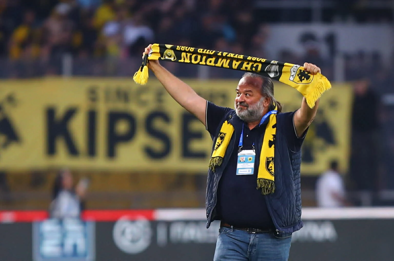 Ο Μάριος Ηλιόπουλος πανηγυρίζει με το κασκόλ της ΑΕΚ από το πρωτάθλημα του 2023 μετά τη σπουδαία νίκη επί του ΠΑΟΚ