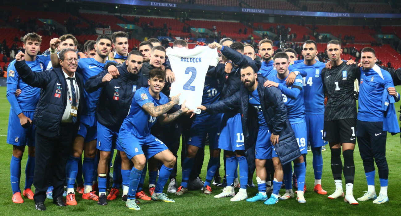 Οι παίκτες της Εθνικής Ομάδας κρατούν τη φανέλα του Τζορτζ Μπάλντοκ με το «2», λίγο μετά την ιστορική νίκη στο Wembley - ΠΗΓΗ: Eurokinissi