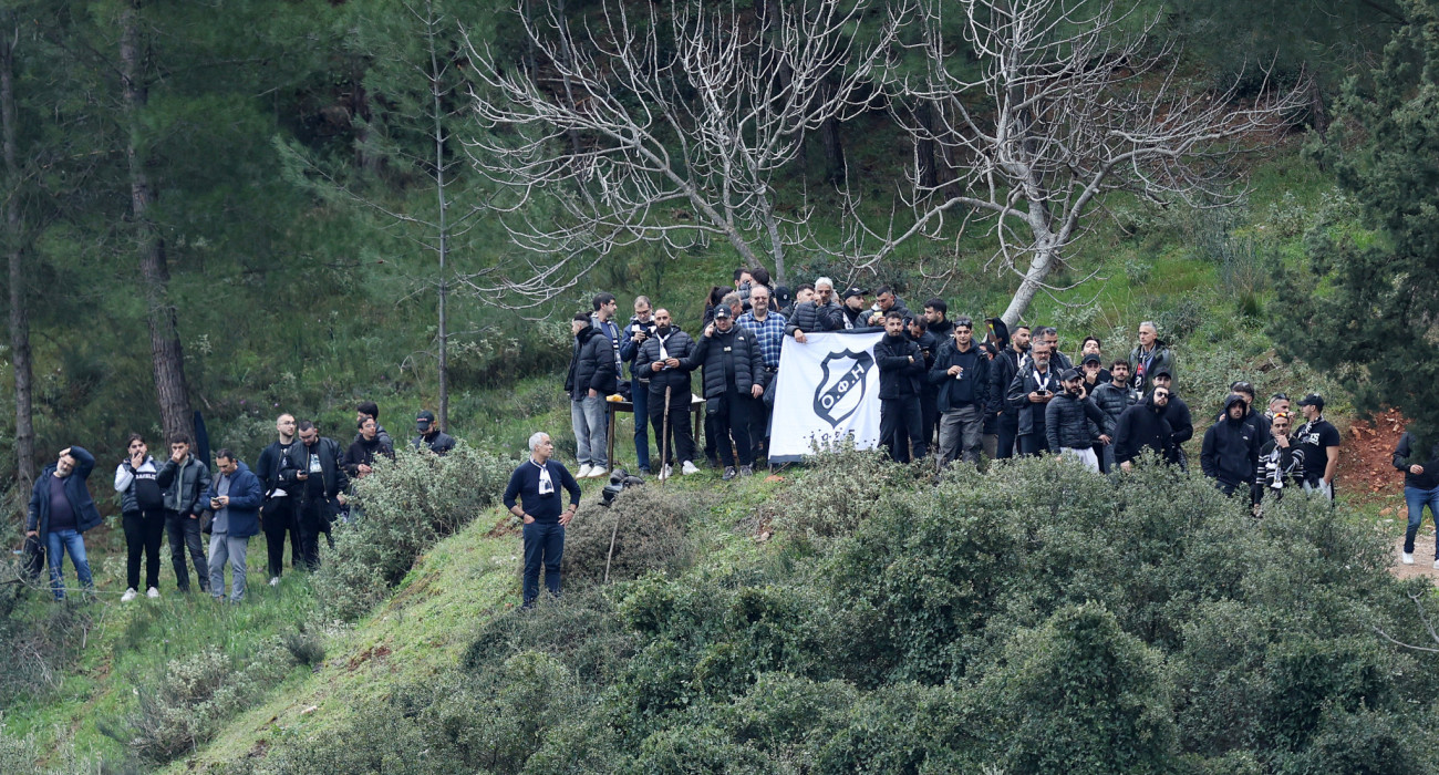Οπαδοί του ΟΦΗ παρακολουθούν το ματς με τον Λεβαδειακό από τον λόφο, πίσω από το γήπεδο / Πηγή: Intime