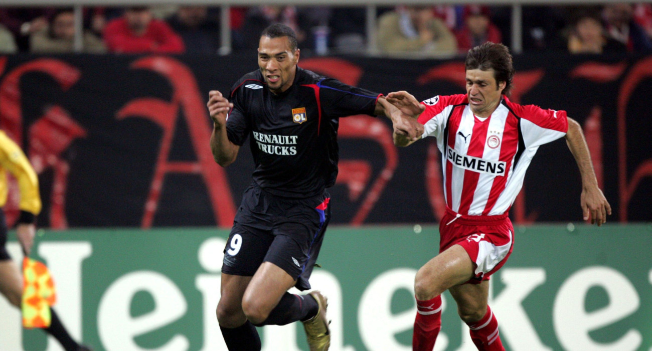 Ο Τζον Κάριου με τον Θανάση Κωστούλα σε αγώνα Ολυμπιακός-Λιόν για το Champions League / Πηγή: Intime